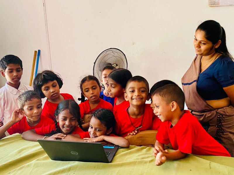 Schoolchildren in Weralugahamula discover how to use a laptop